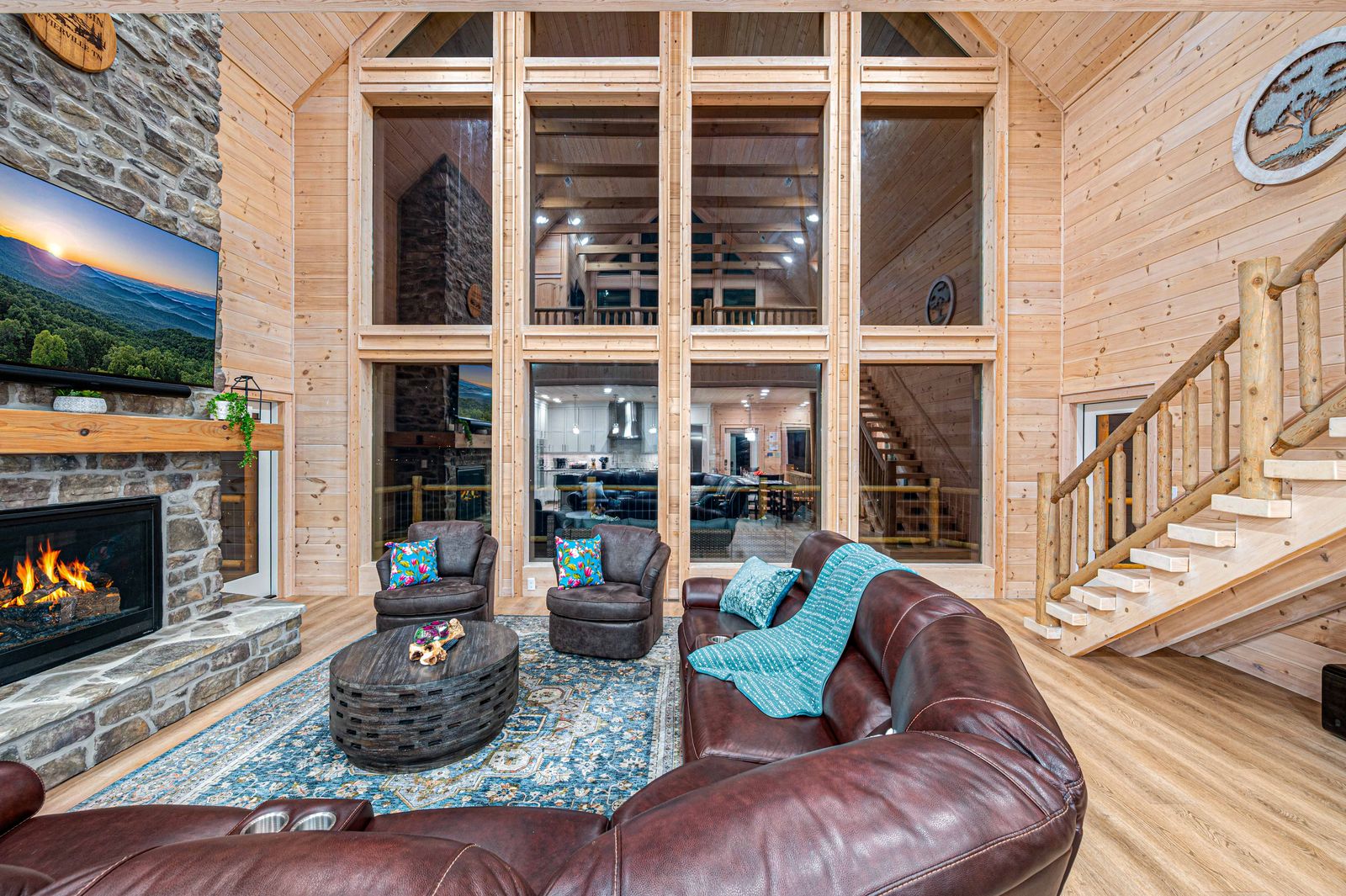 The great room at night beneath the two-story wall of windows