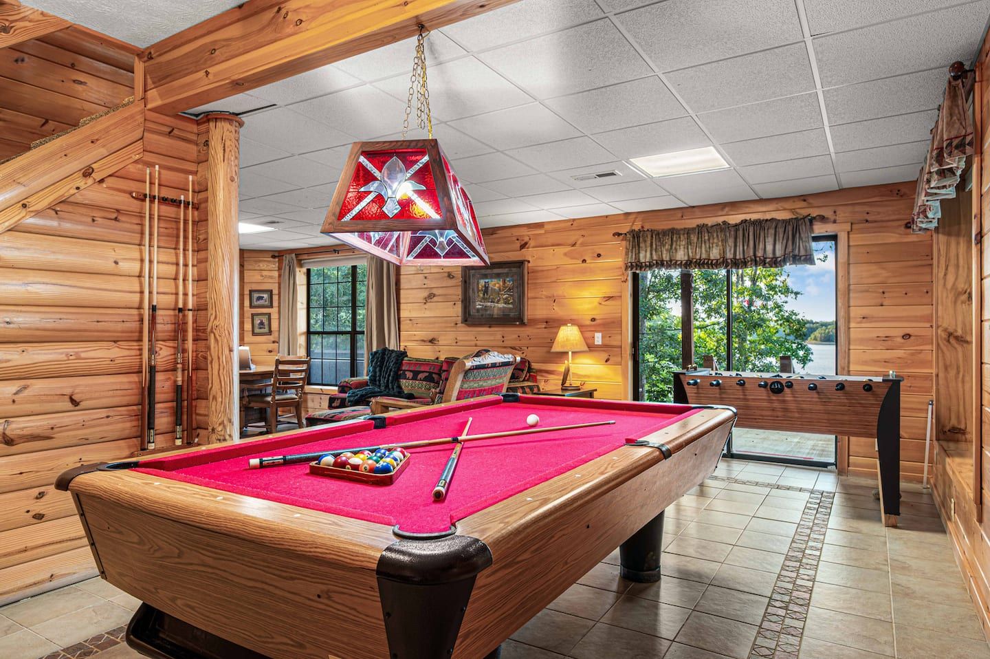 The game room has a pool table, poker table, foosball, and a lake view. Rain, wind, or just a slow afternoon, it settles the day.