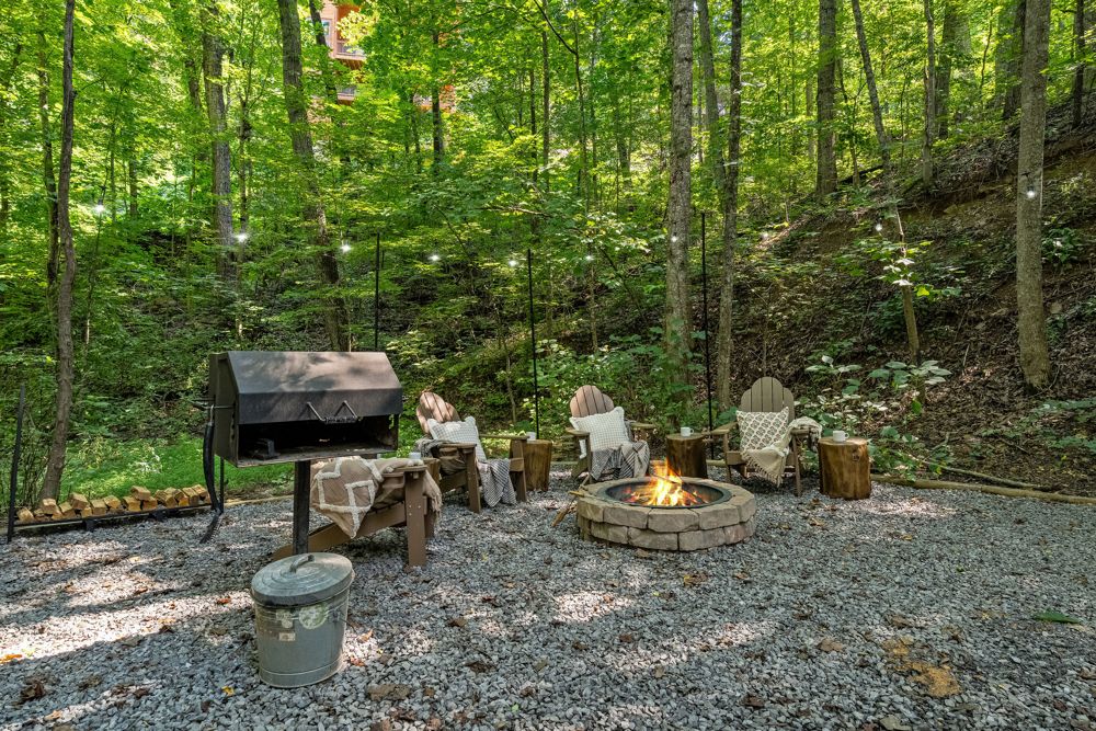 Adirondack chairs around the fire pit in the woods