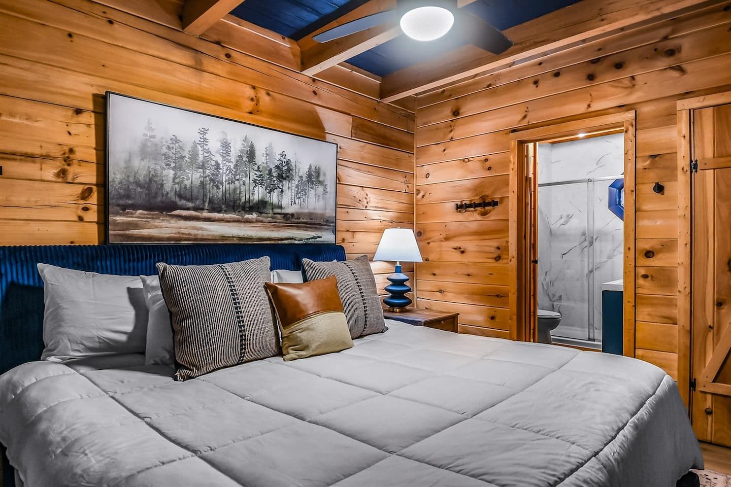 The master bedroom features a king bed with soft linens and ample pillows, offering a calm space to rest and recharge. Its ensuite bathroom provides comfort and privacy.