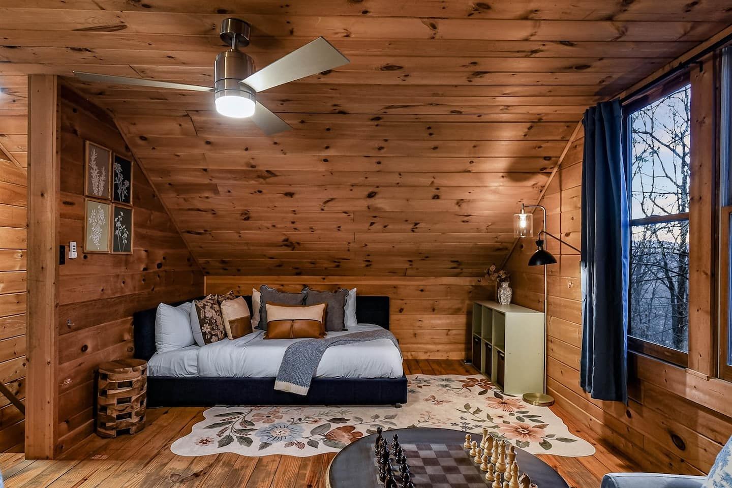 The loft feels calm and intentional — a tucked-away sleeping space inviting deep rest. The window frames quiet forest views, letting you wake slowly to the trees and enjoy a sense of peaceful separation from the world below.