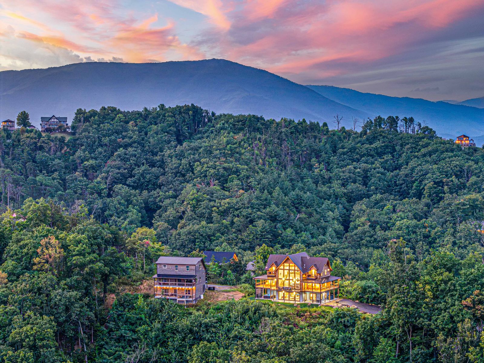 The cabin tucked into the ridge with mountains beyond
