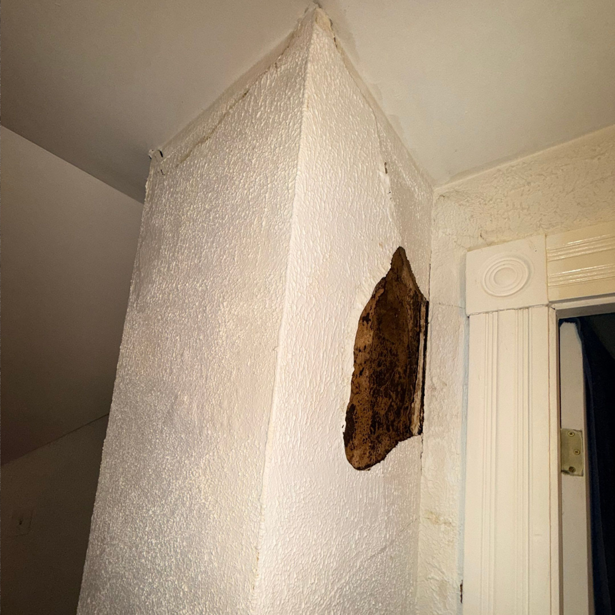 Interior wall damage from chimney leak showing water stains and drywall issues