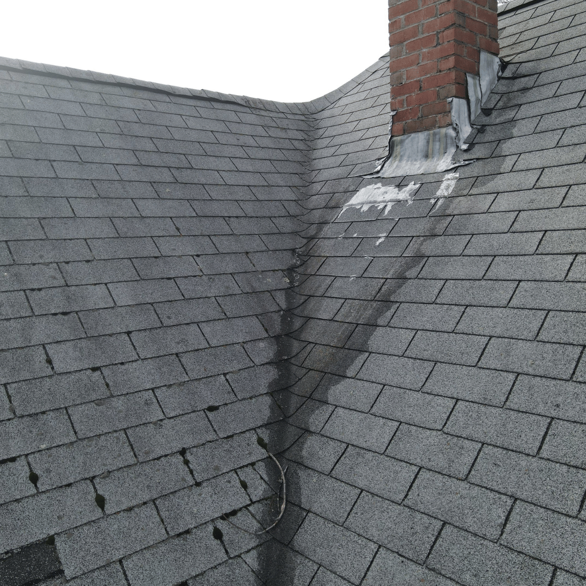 Roof chimney with worn flashing and shingle wear in Greater Boston home