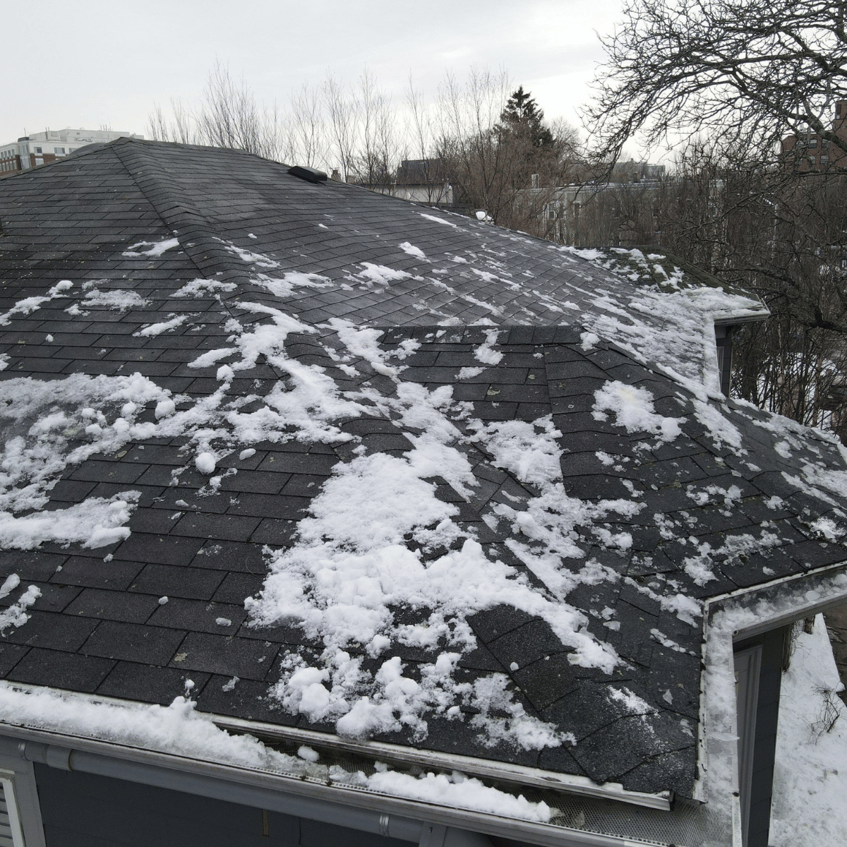 Uneven snow melting on roof showing possible heat loss and ice dam risk