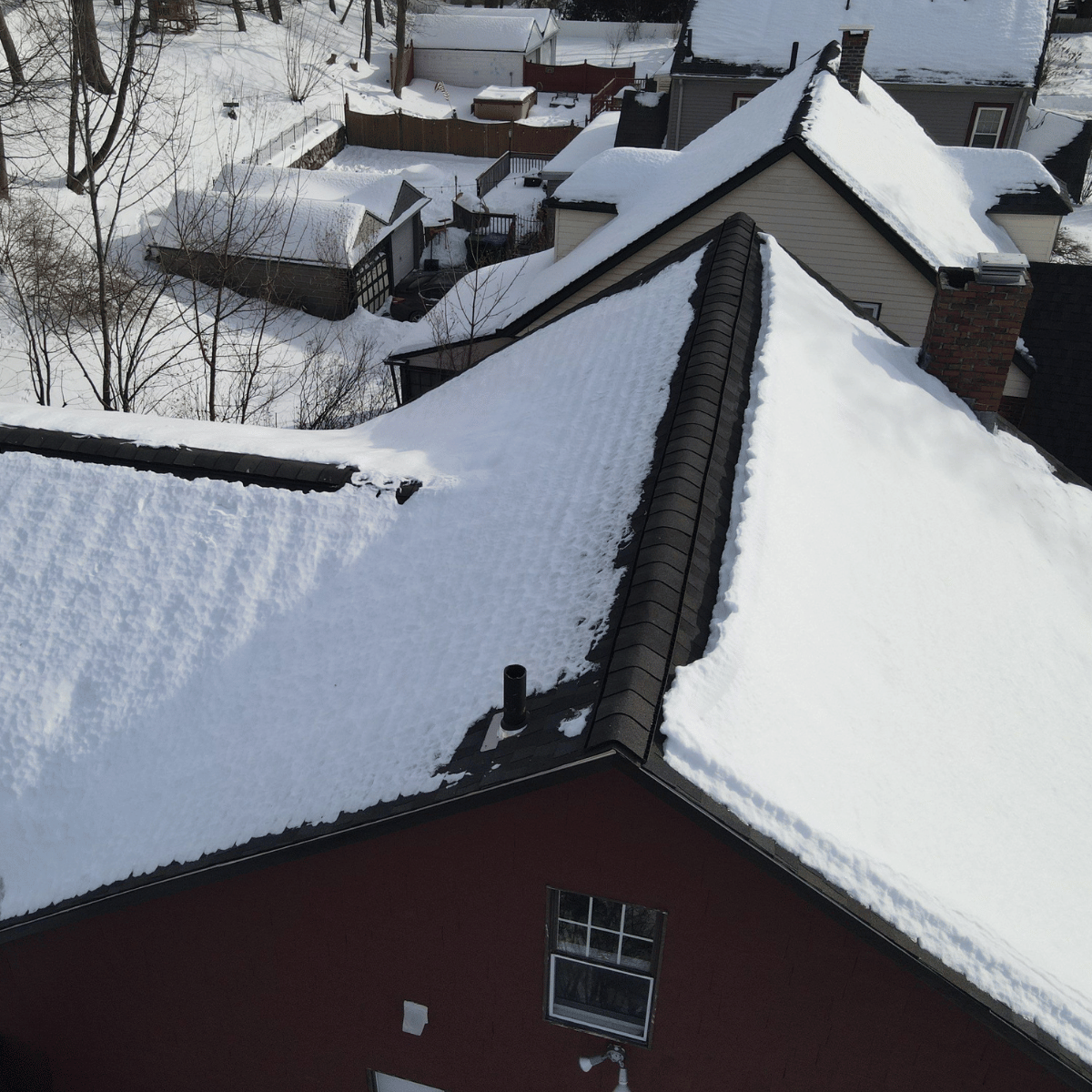 Snow-covered residential roof showing winter ice dam conditions