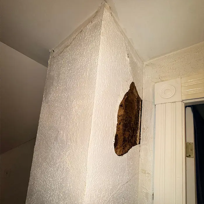 Interior wall damage from chimney leak showing water stains and drywall issues