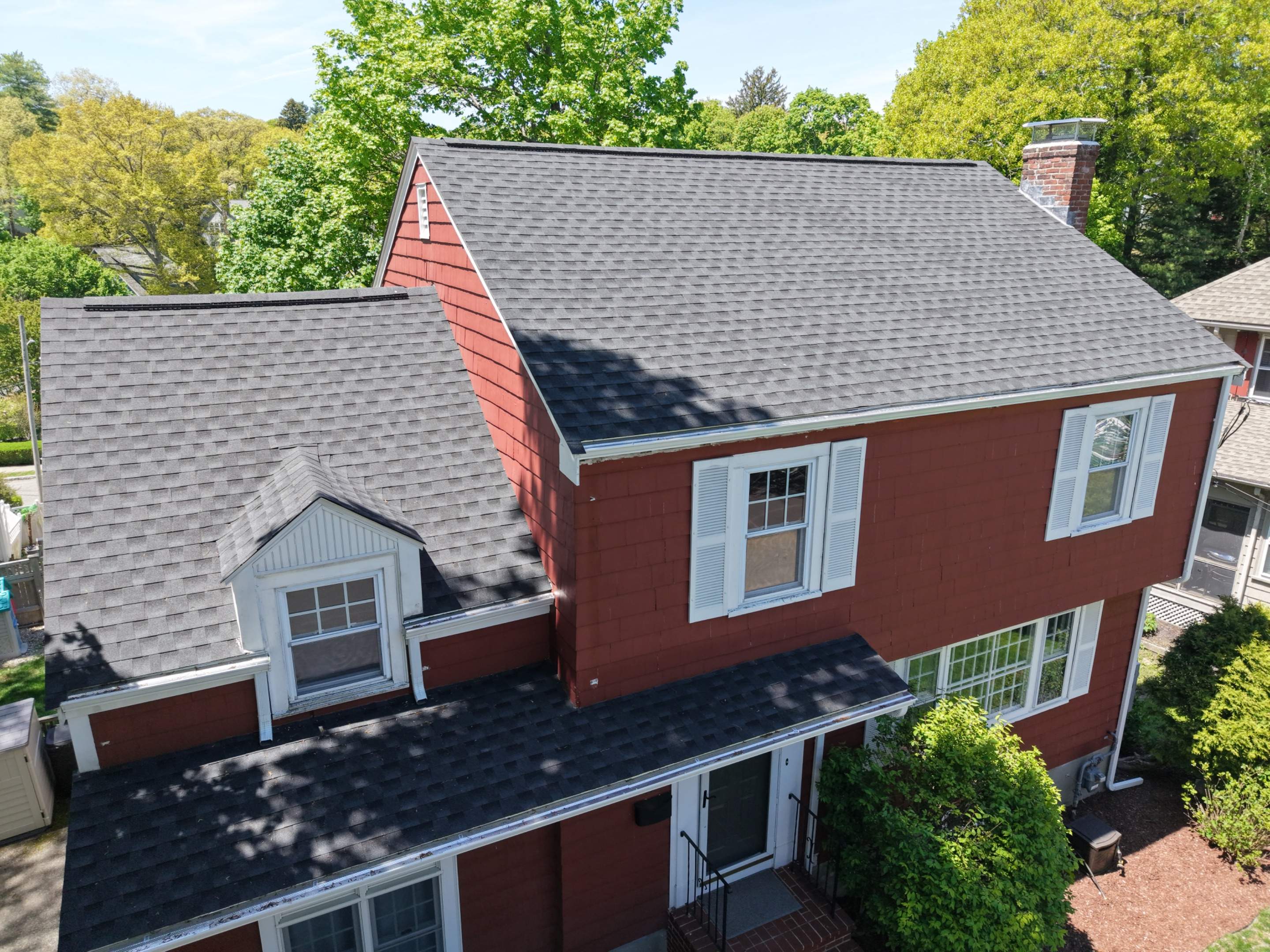 Drone view of a completed asphalt shingle roof replacement on a residential home
