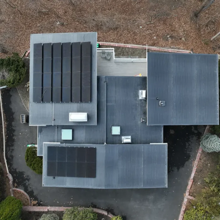 Roof with solar panels requiring roof replacement and solar panel removal in Massachusetts.