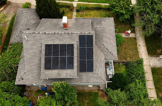 Roof replacement with solar panels on a residential home in Massachusetts.