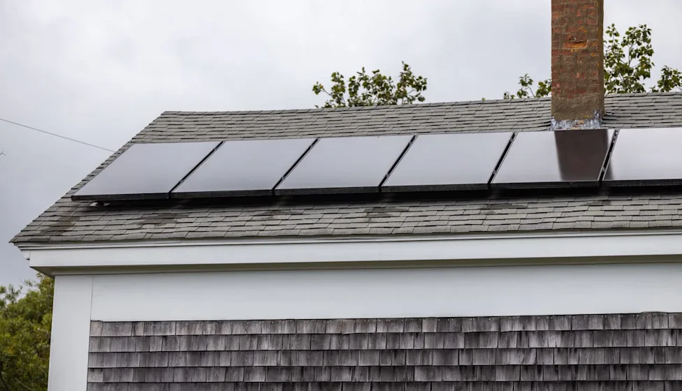 Residential roof with solar panels installed on an asphalt shingle roof in Massachusetts.