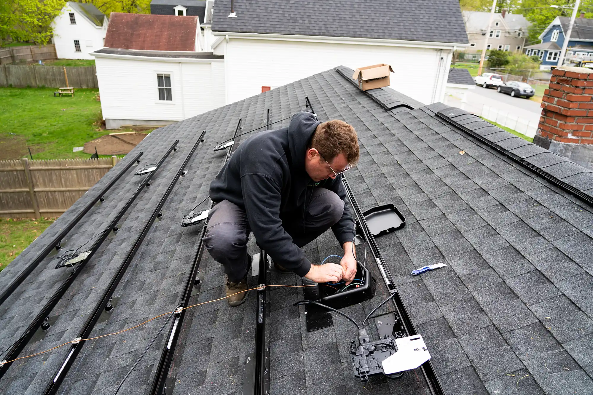 Solar panel mounting rails exposed during roof replacement on a residential home in Massachusetts.