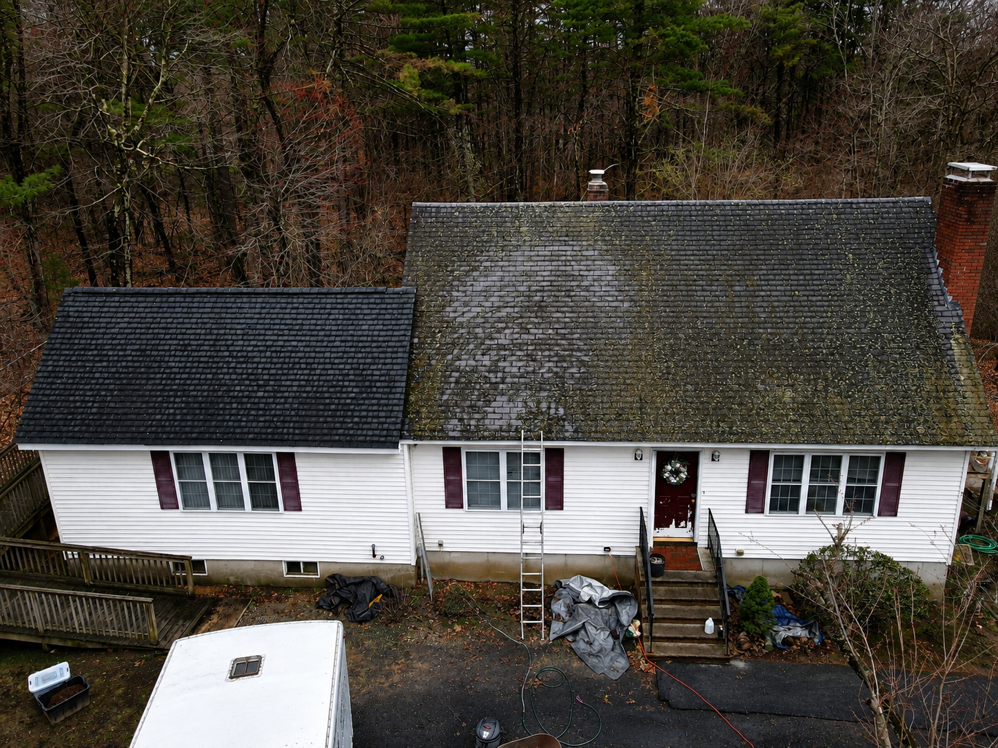 `Aerial view of an asphalt shingle roof with heavy moss and algae growth on a home in Malden, MA`