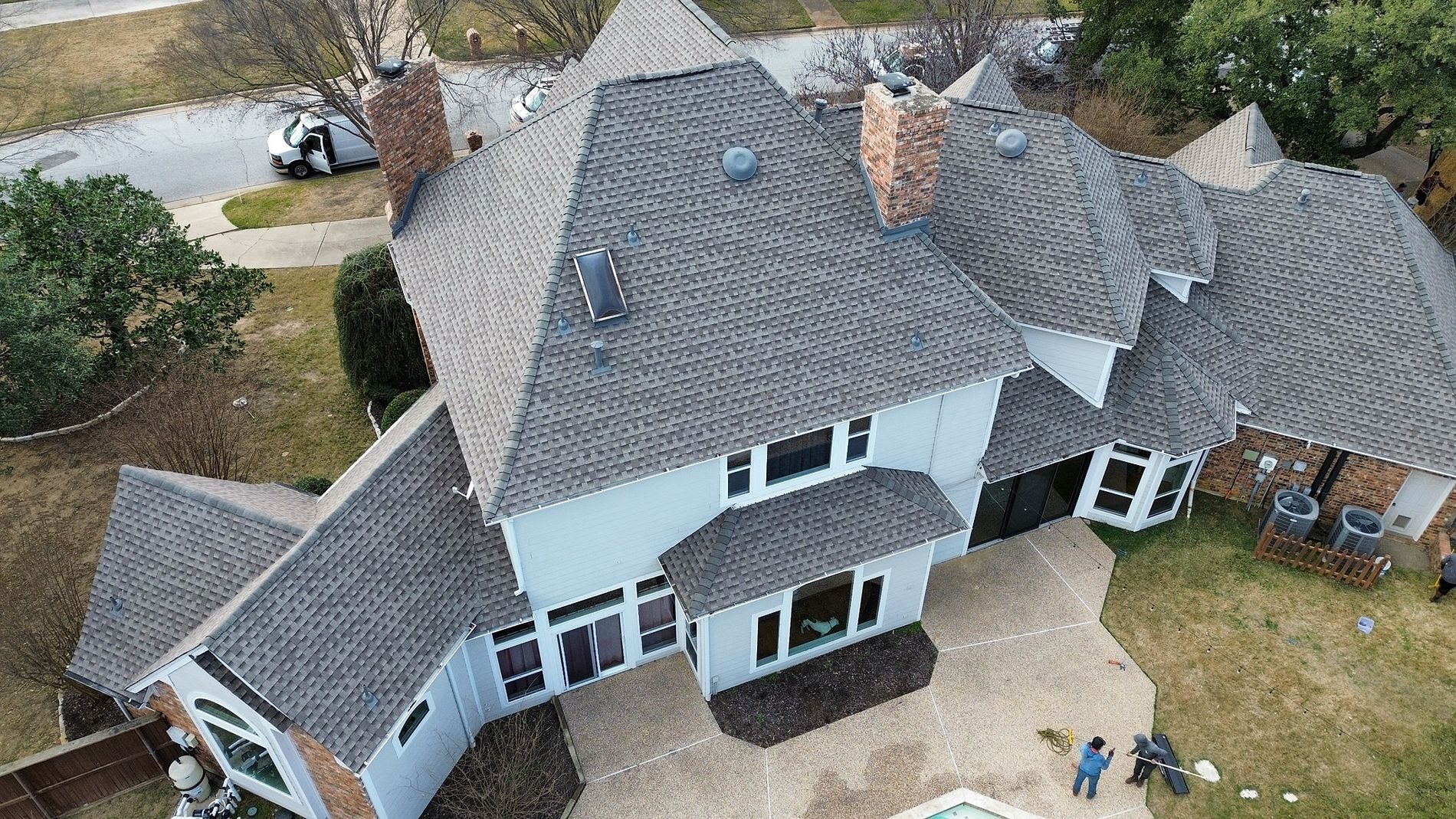 Aerial view of a new gray shingle roof on a two-story home