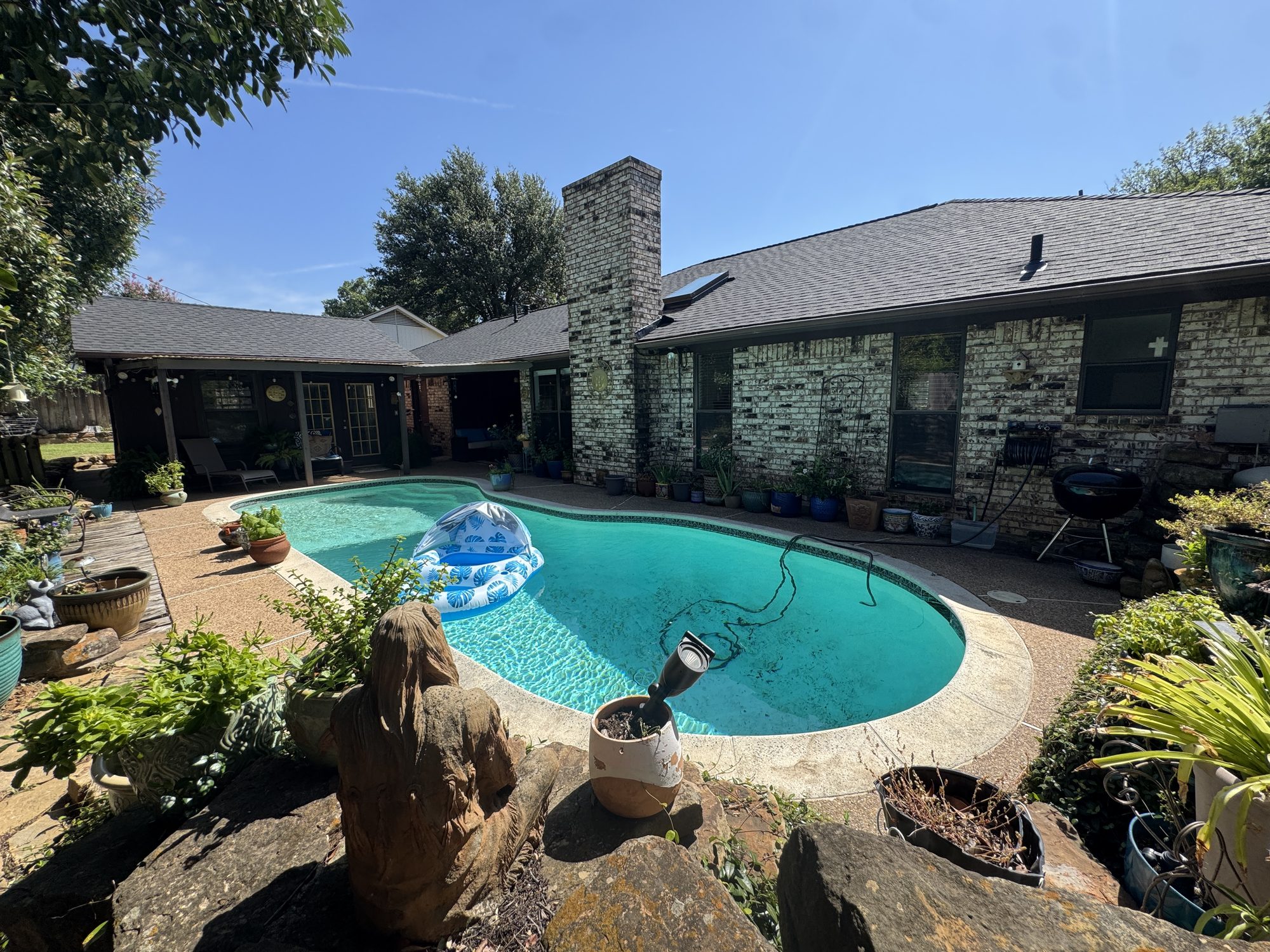 Finished roof on a brick home with a backyard pool