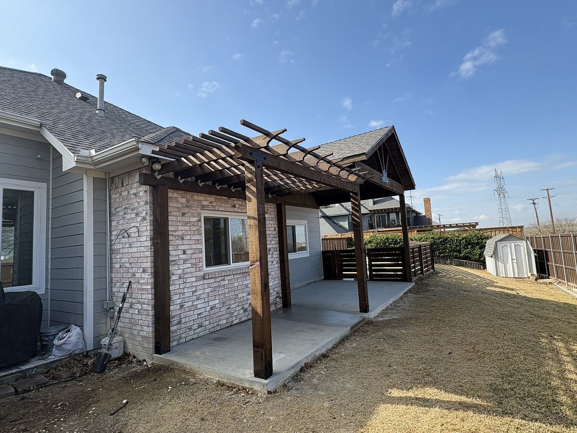 New dark stained pergola over a back patio