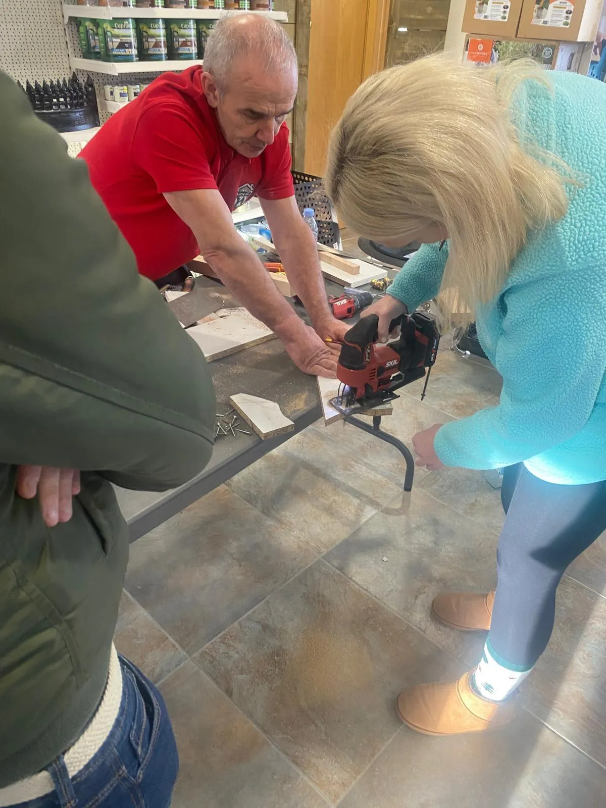 Jimmy assisting a woman using a jigsaw