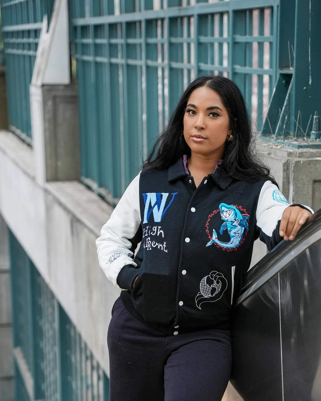 Model in the black High Current jacket by teal railings