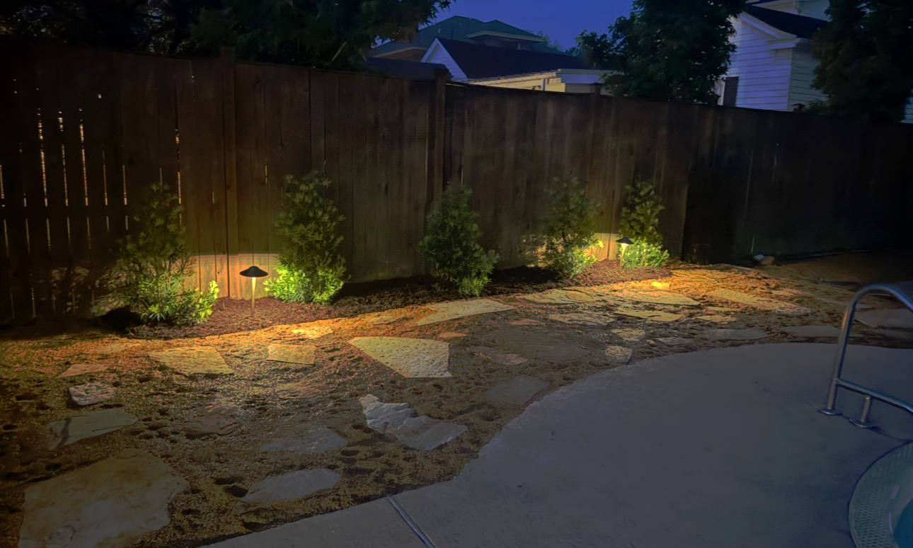 Landscape lighting illuminating stone pathway at dusk in Columbus, Mississippi