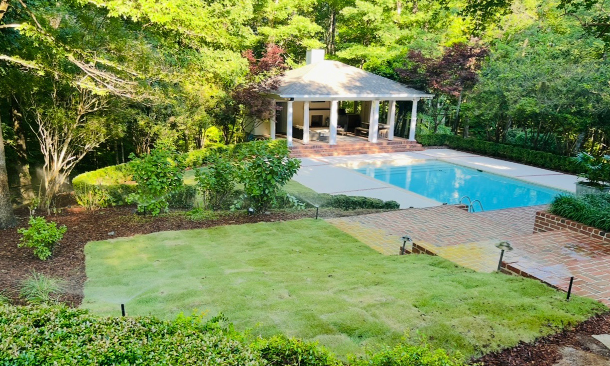 Completed residential landscape with stone hardscape and green lawn in Columbus, MS