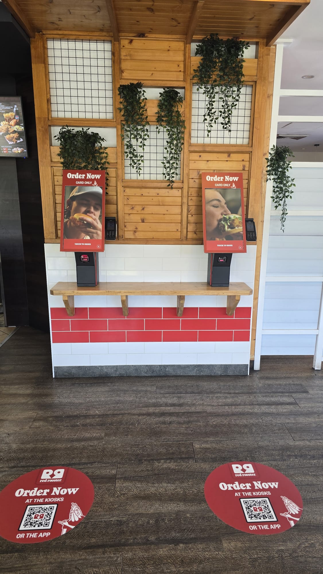 Close view of Red Rooster floor decals directing customers to the kiosks and app Close view of Red Rooster floor decals directing customers to the kiosks and app