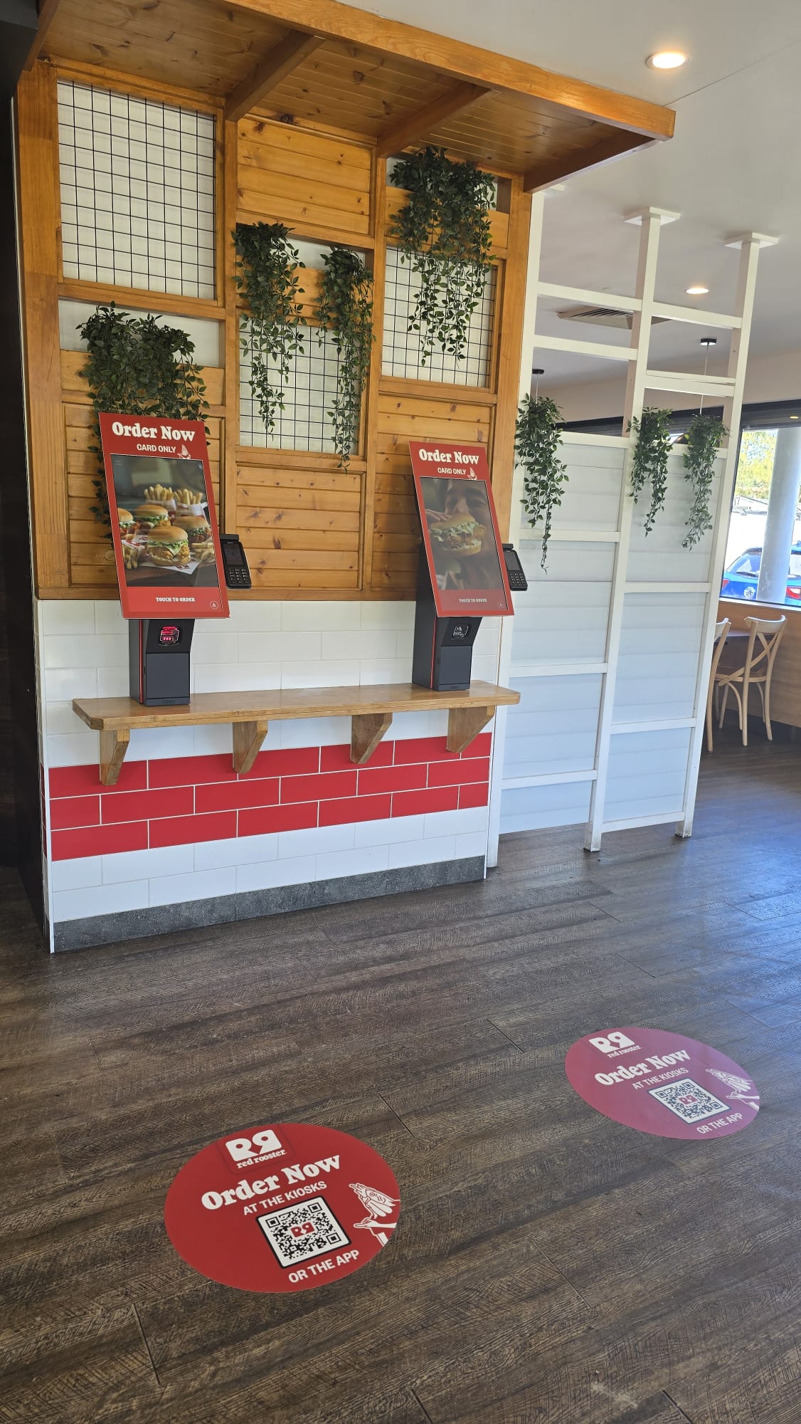 Red Rooster ordering kiosks with circular floor graphics and QR codes Red Rooster ordering kiosks with circular floor graphics and QR codes