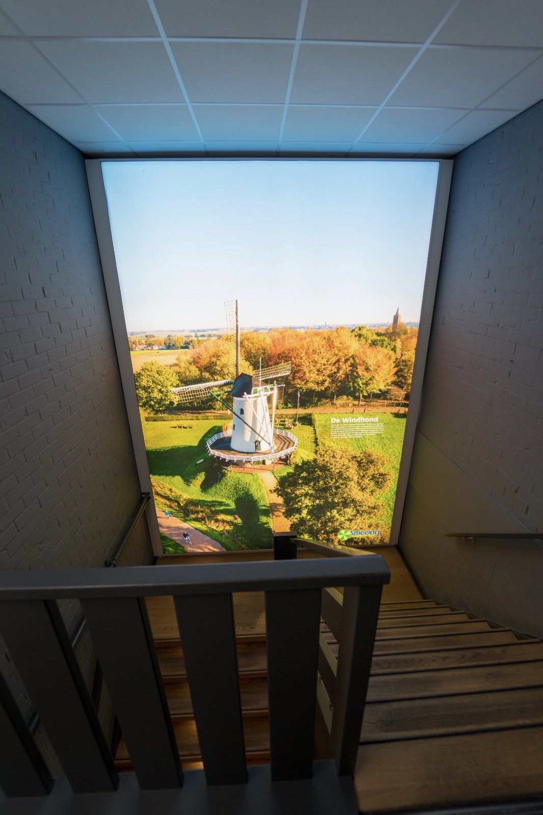 Trappenhuis bij Auto Smeeing met een hoog, smal Wisseldoek van een landschap