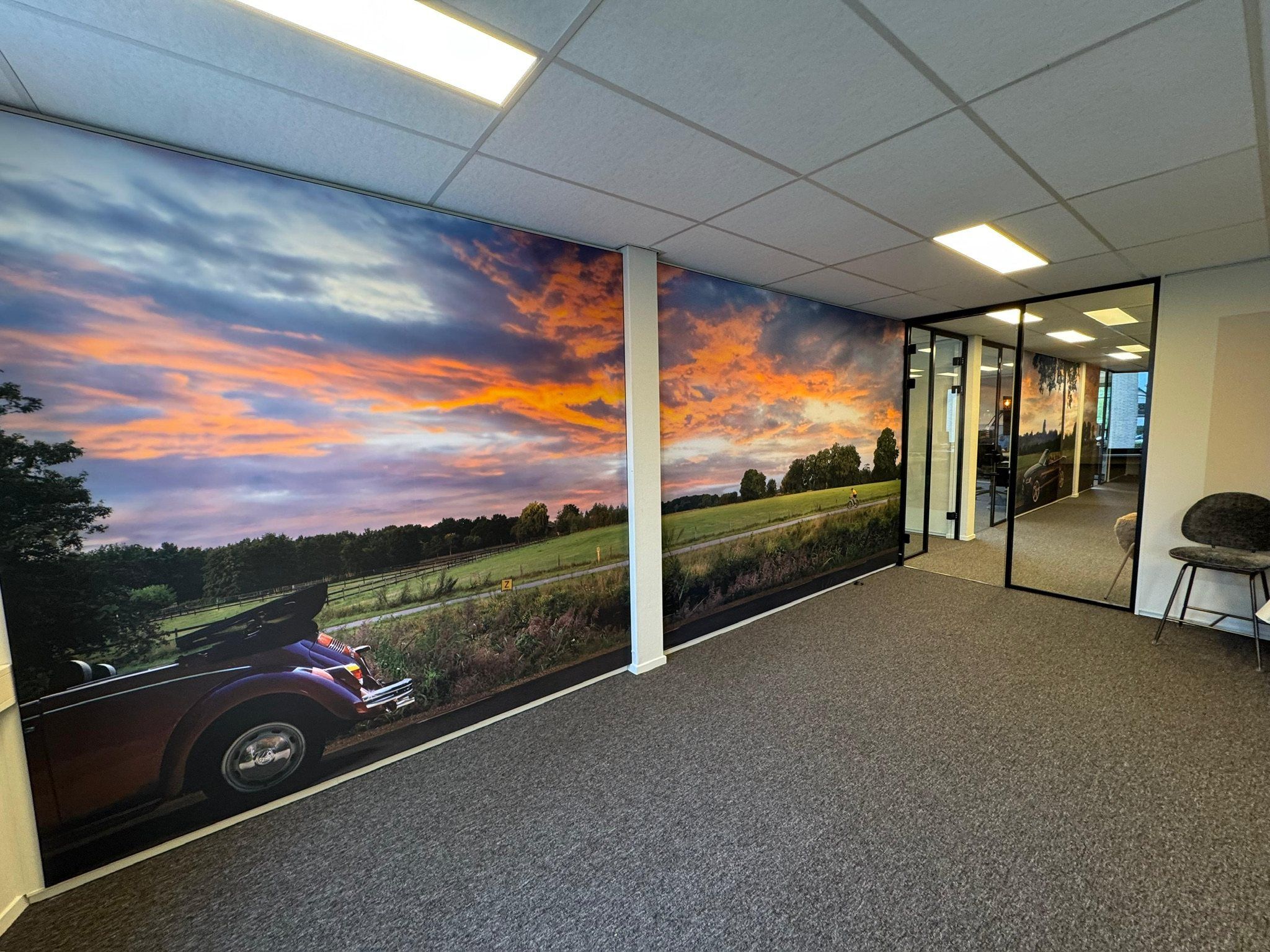 Kantoor van Captive Finance met een groot Wisseldoek van een landschap bij zonsondergang