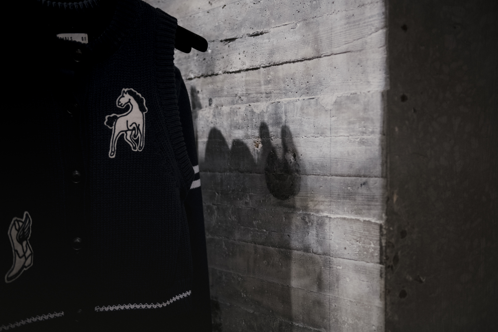Zwaar betonnen muur achter kleding met paardenprint