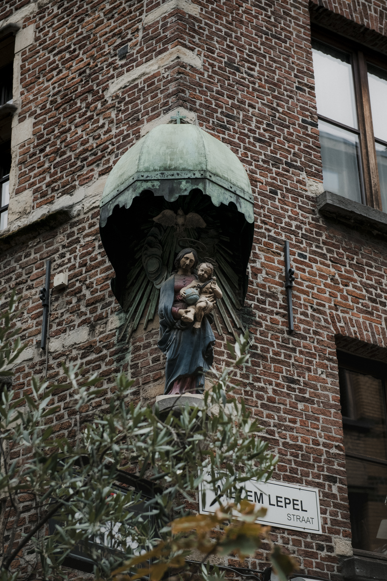 Antwerpse straat met heilig beeld ingebouwd in hoek van een pand