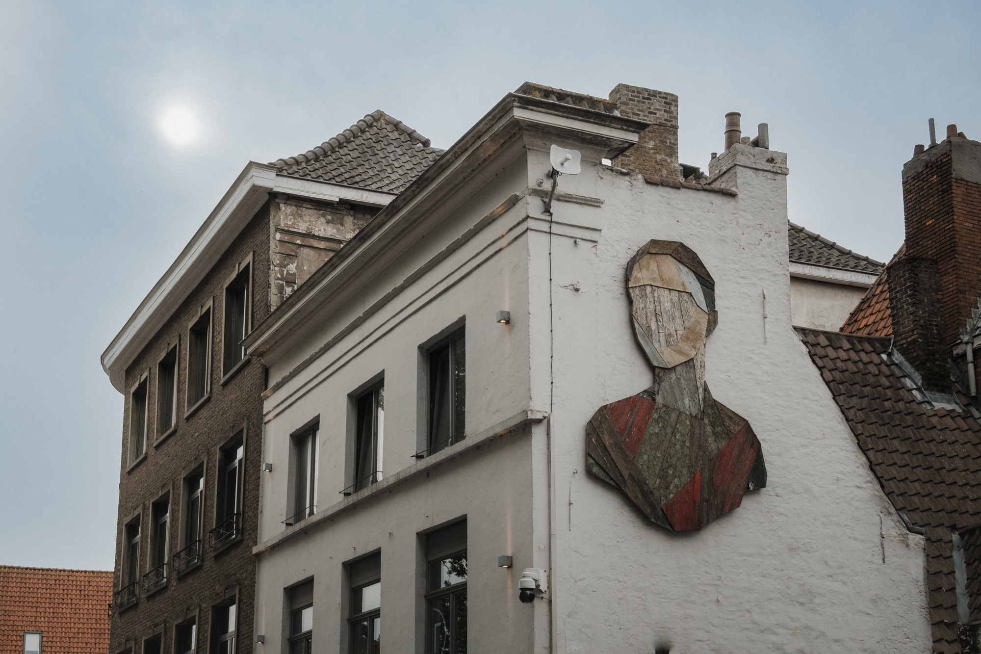 Gevelkunst van hout tegen zijkant gebouw en zon 