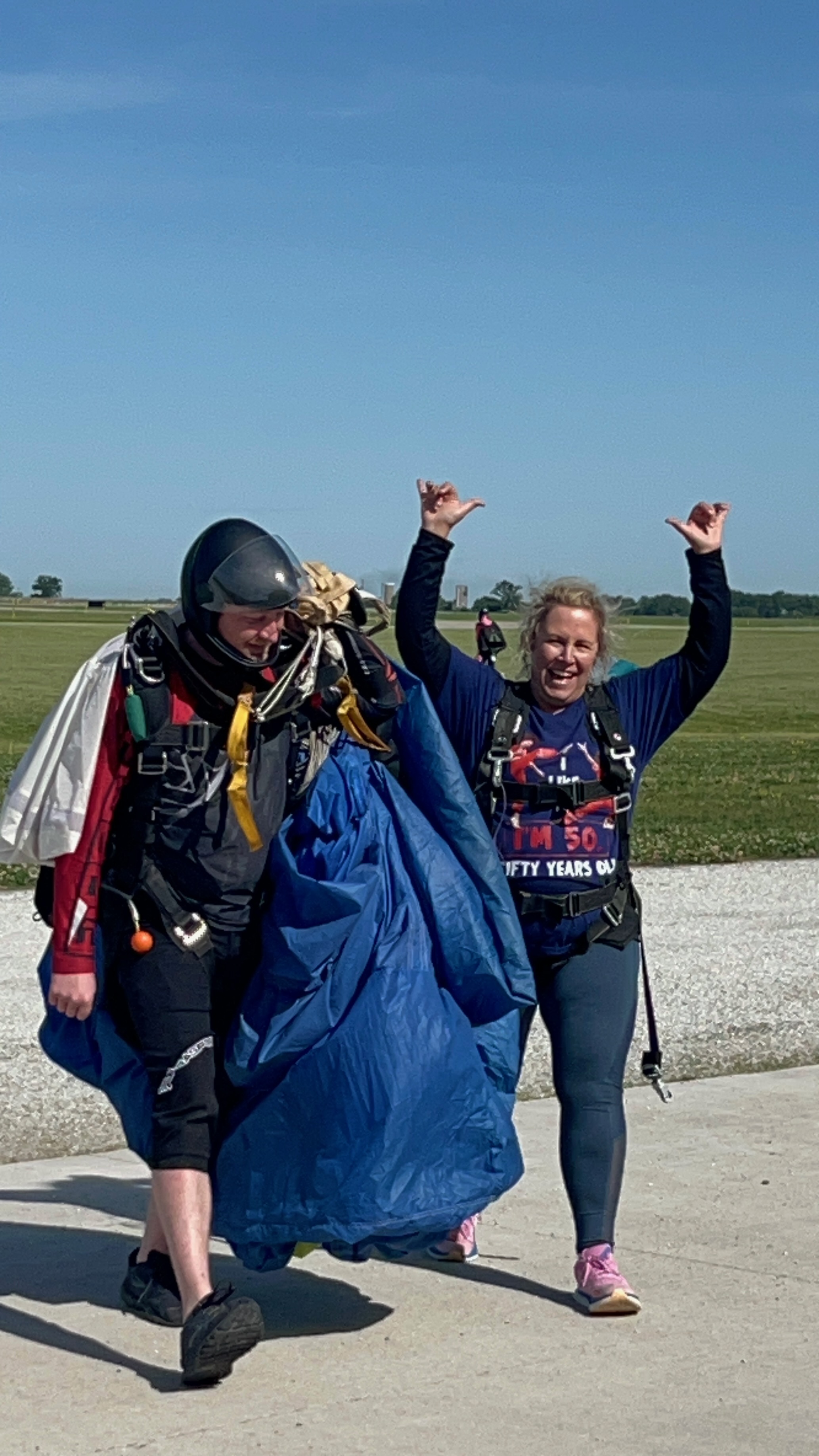 Wendi after skydiving, arms raised