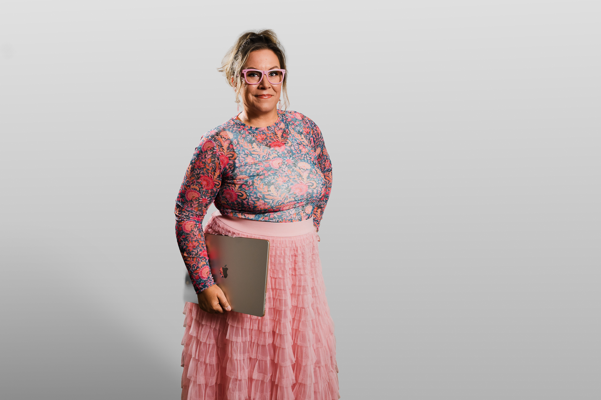Wendi standing, laptop tucked under her arm, ready