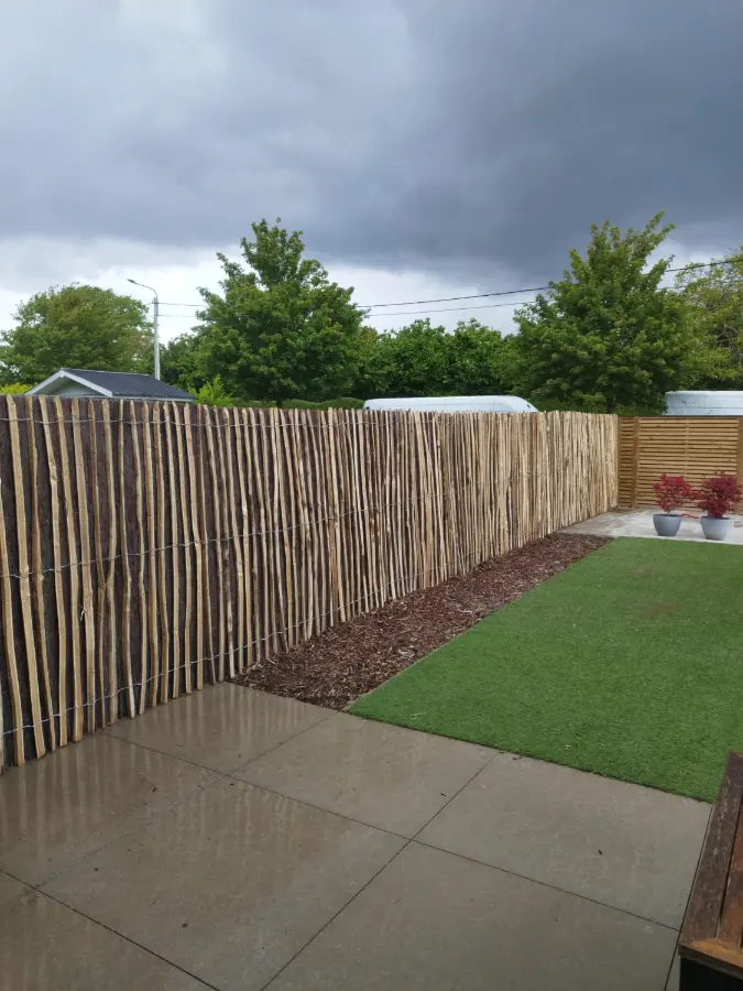 Detail van geïmpregneerde houten tuinschermen stevig verankerd tussen gewapende betonpalen