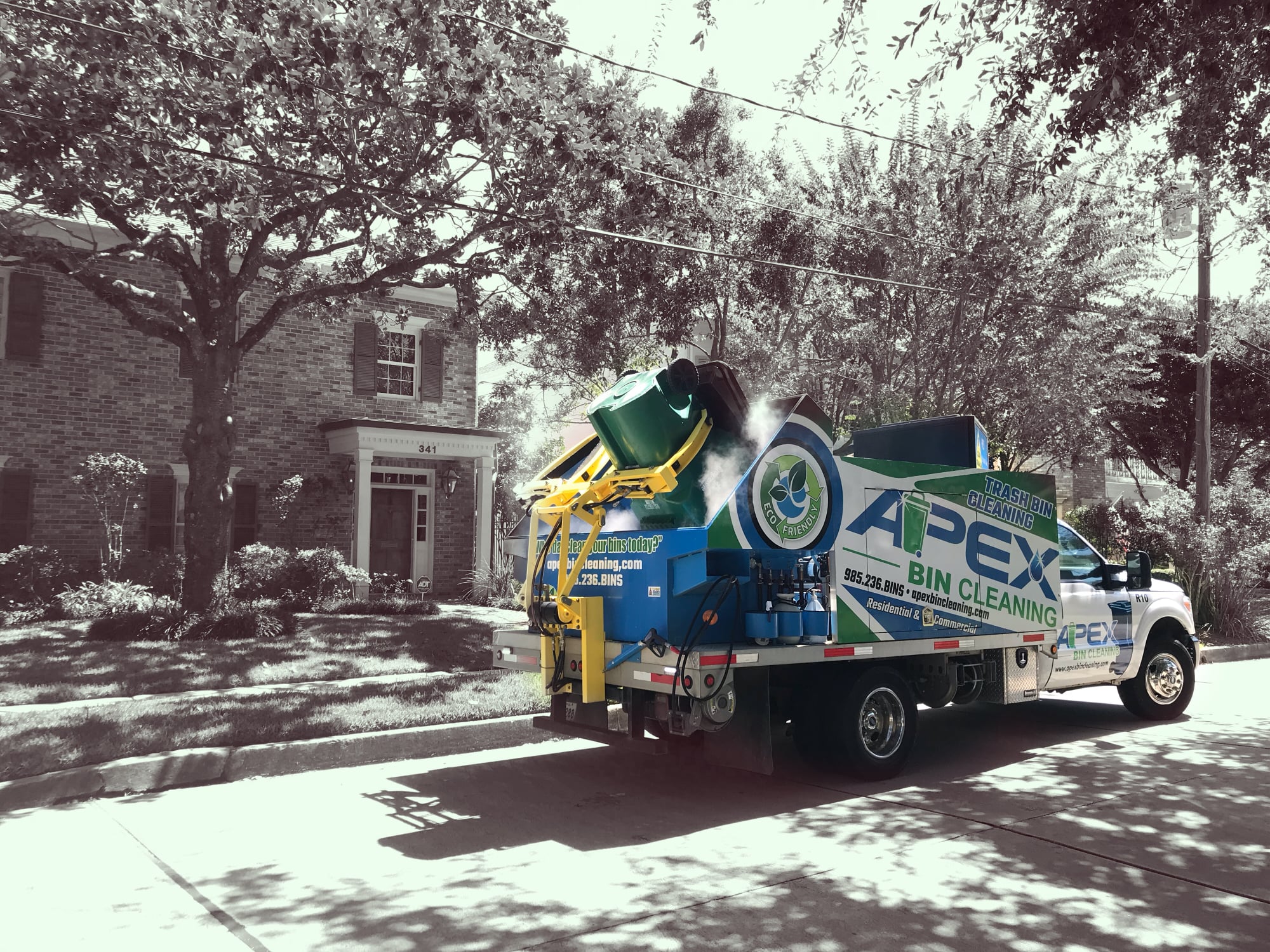 What A Bin truck cleaning trash and recycle bins with a self-contained hot steam cleaning unit on a sunny residential street in San Diego, California.