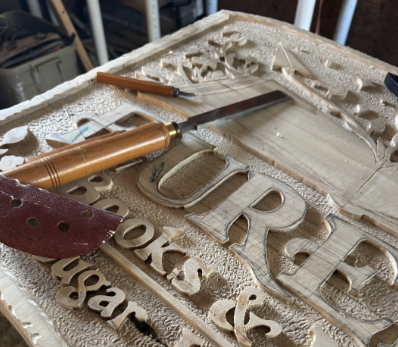 Hand carved wooden sign for Eureka Books and More by Sundanced Wood in Sugarloaf New York