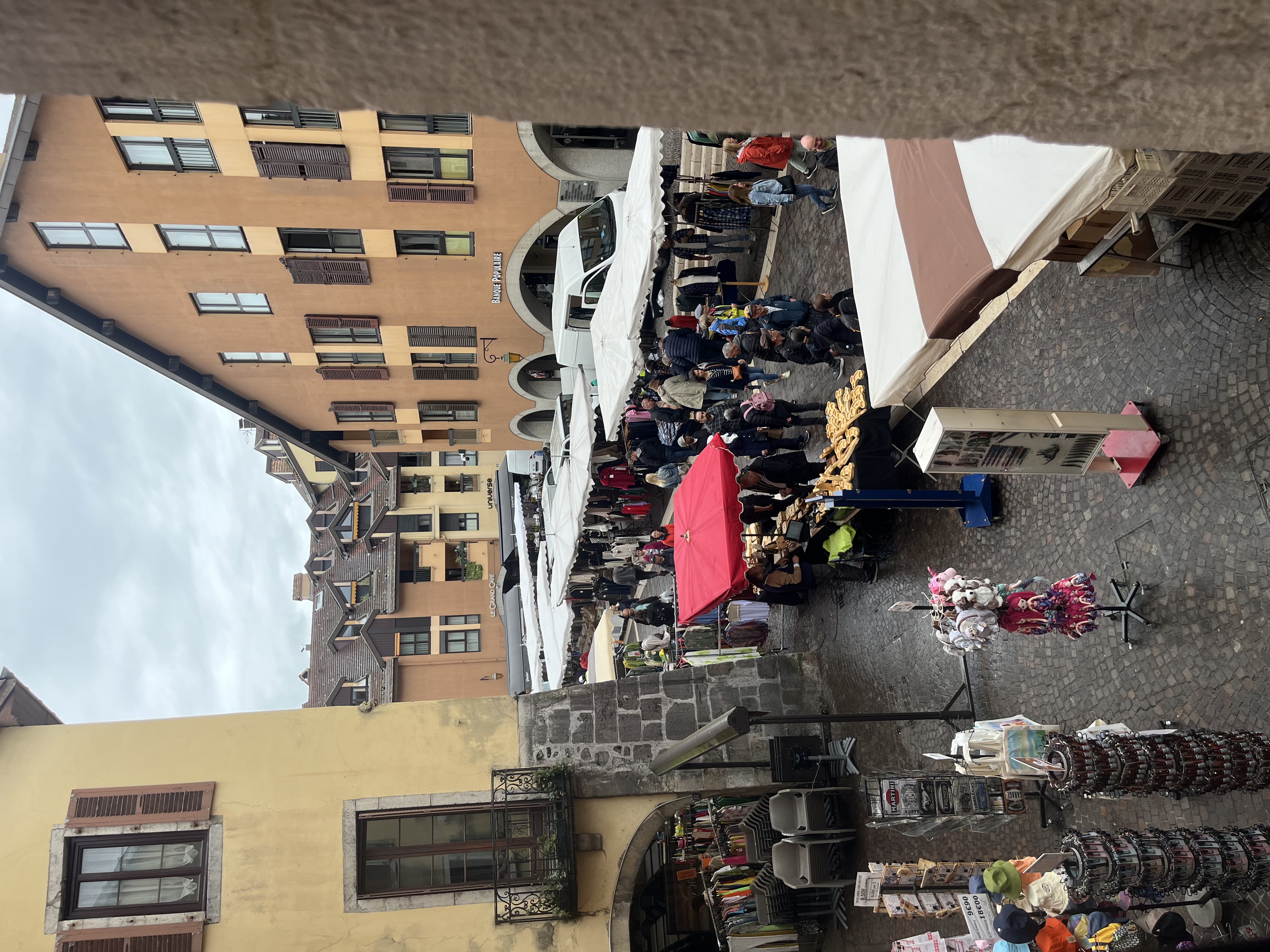 Market stalls at Annecy seen from above with colorful awnings
