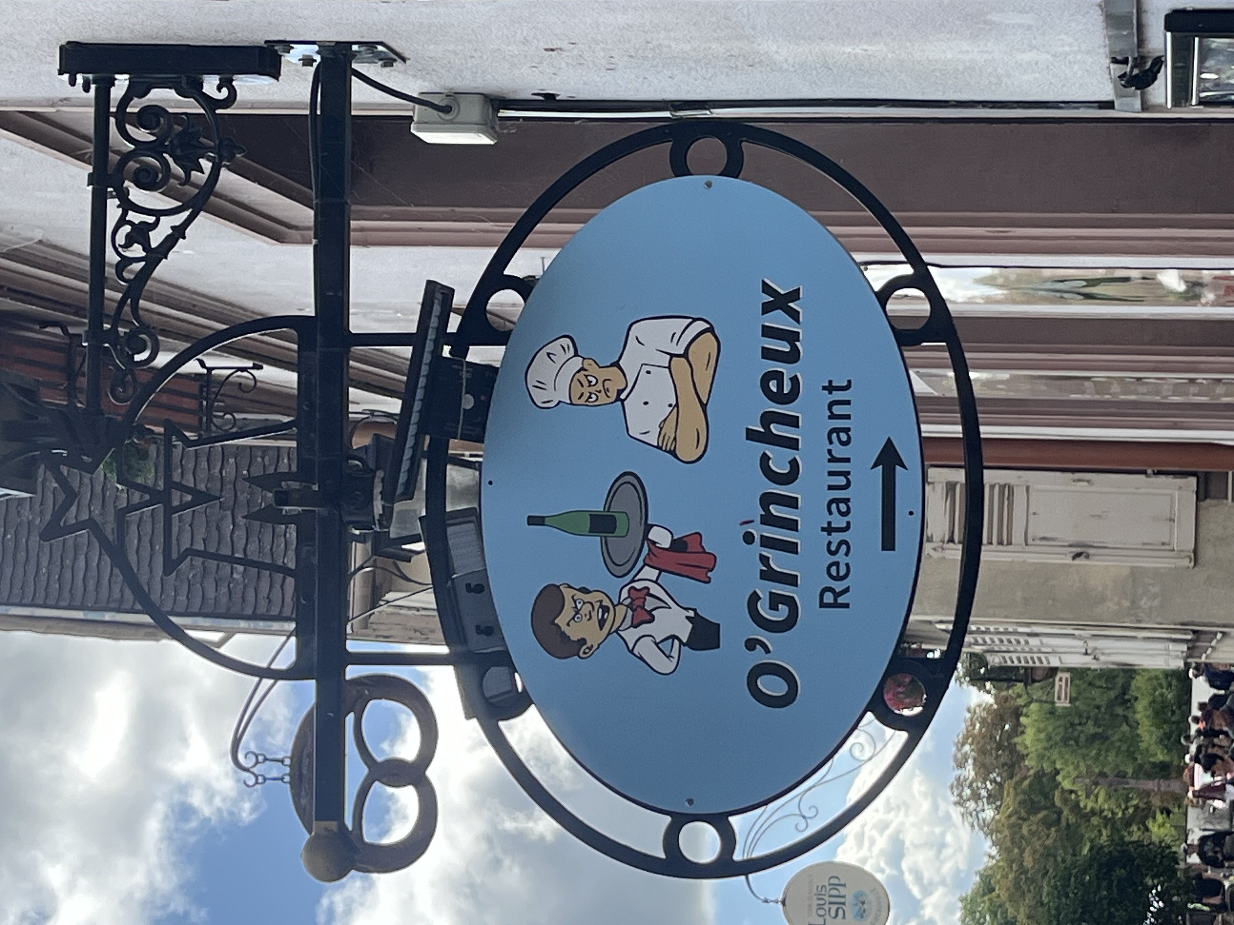 O'Grincheux restaurant sign with grumpy chef and waiter