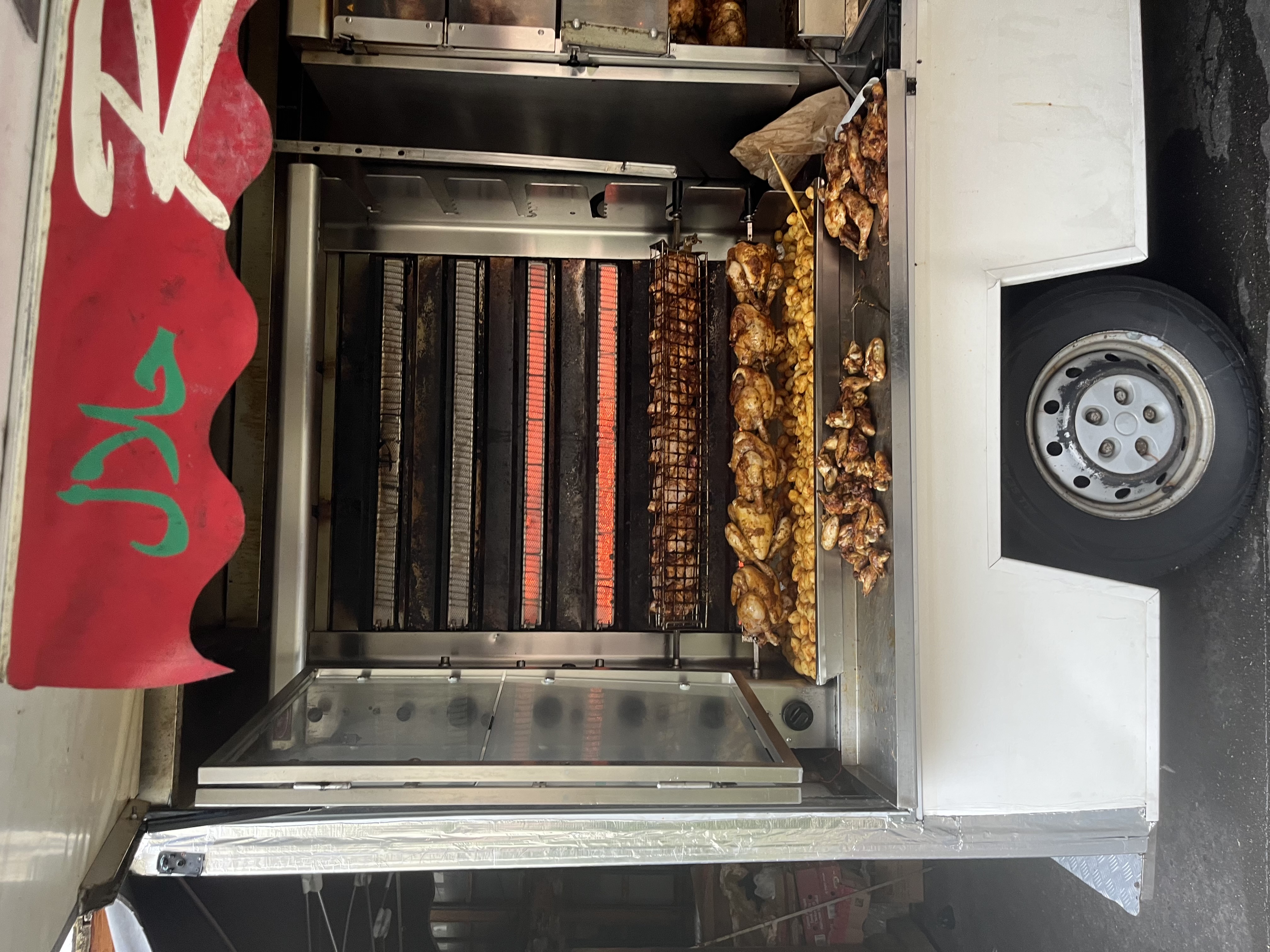 Rotisserie chickens turning on a spit at the Annecy street market