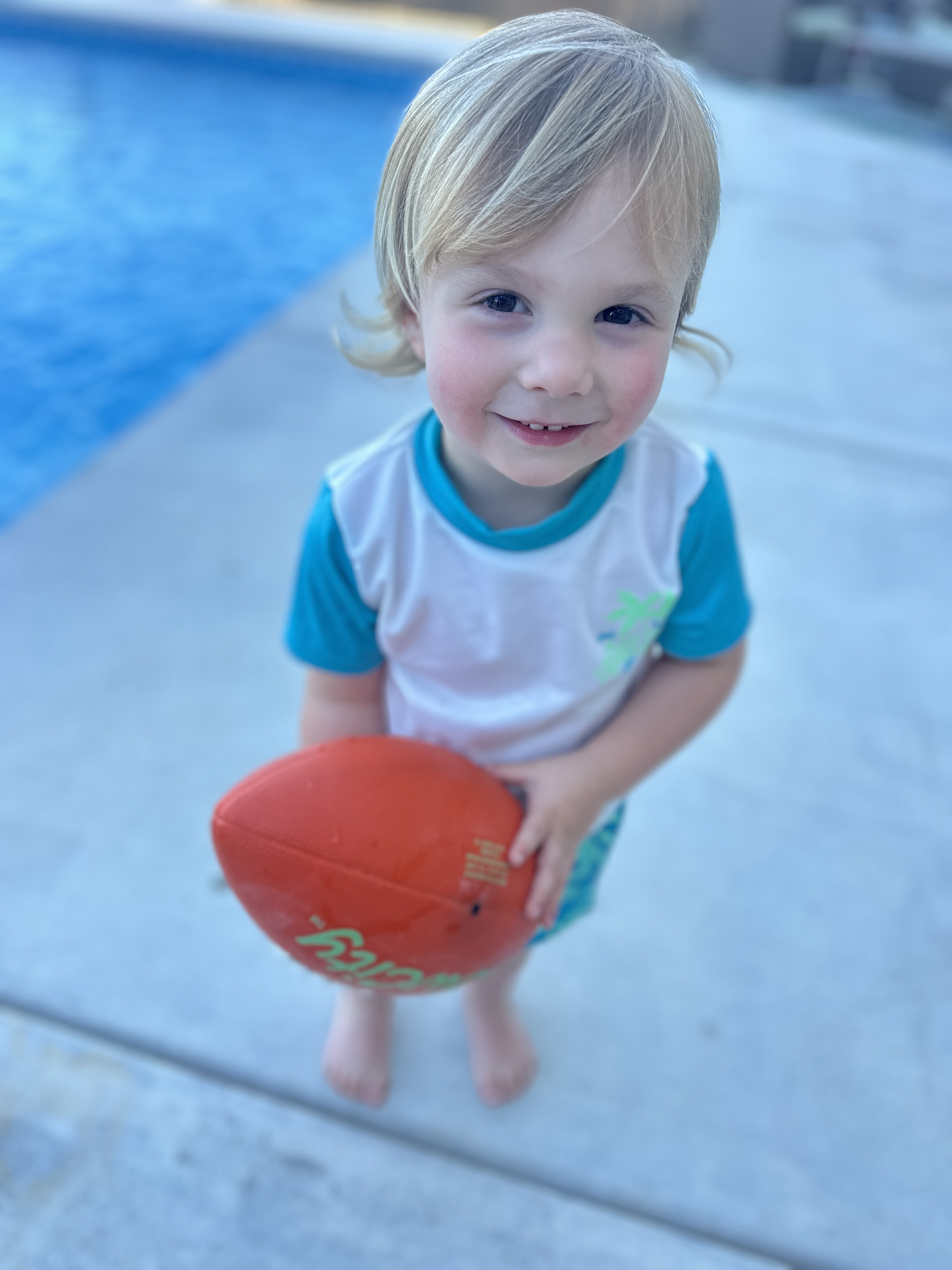 Young swimmer with football