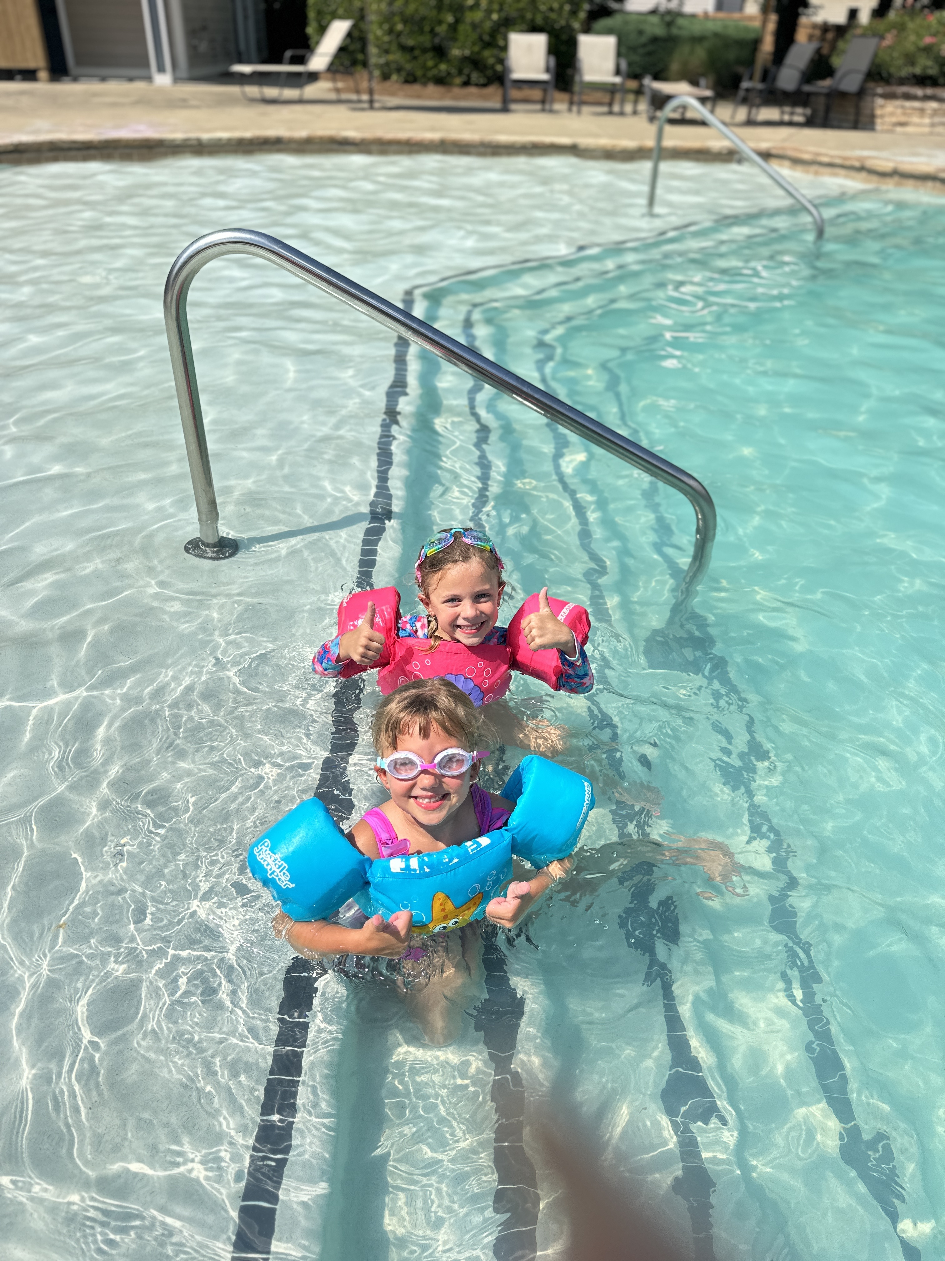 Children playing in pool with flotation devices