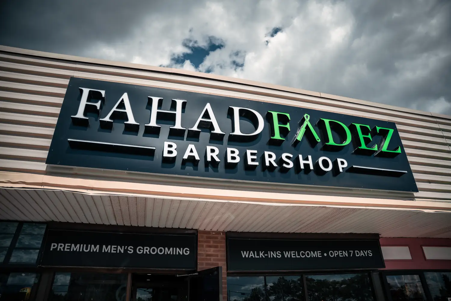The lit FahadFadez Barbershop sign above the storefront in Winston Churchill Plaza