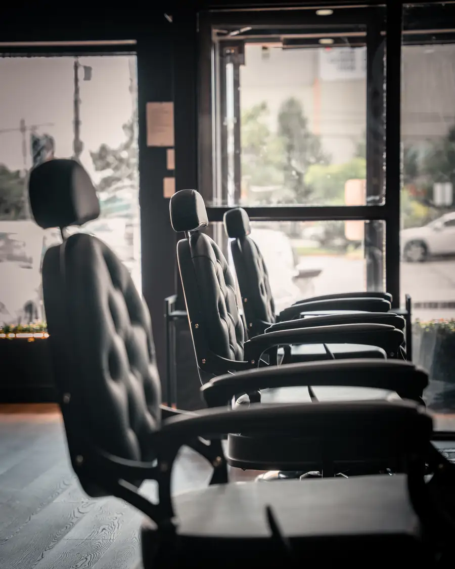 Empty barber chairs by the front window of the shop