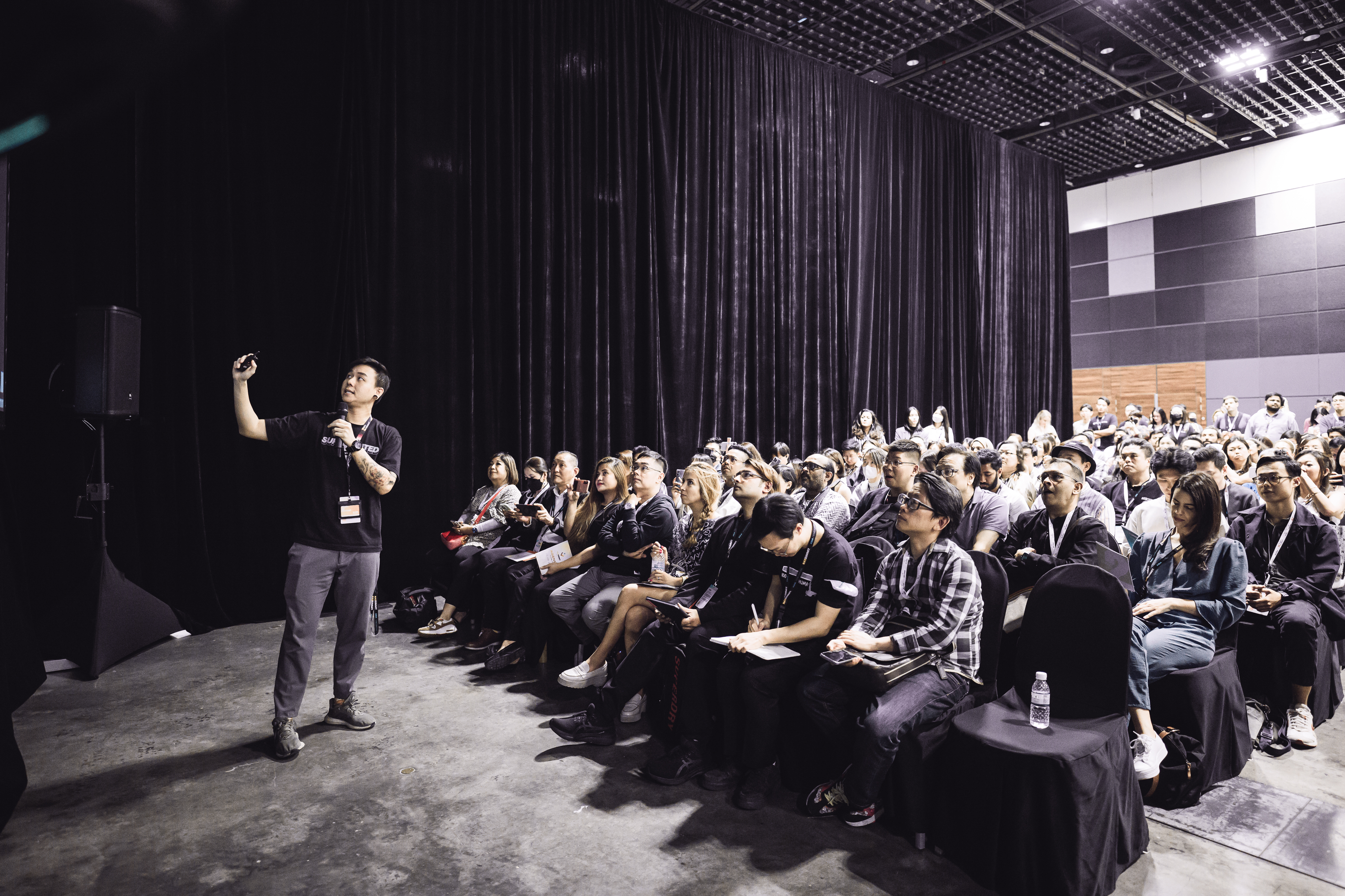 Miah on stage in front of a full room