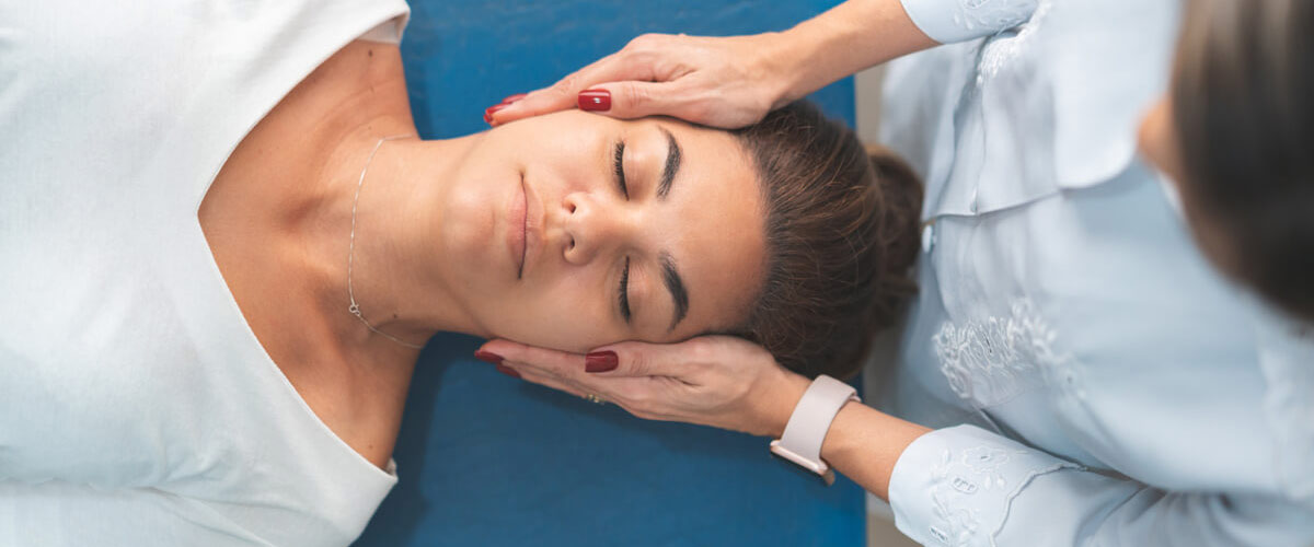Woman laying face up on table, about to receive a neck adjustment from Chiropractor.