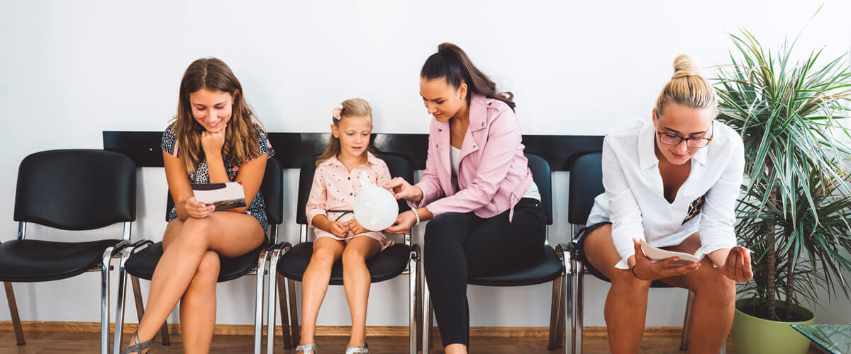 Women and girls wait in a waiting room at a doctor's office.