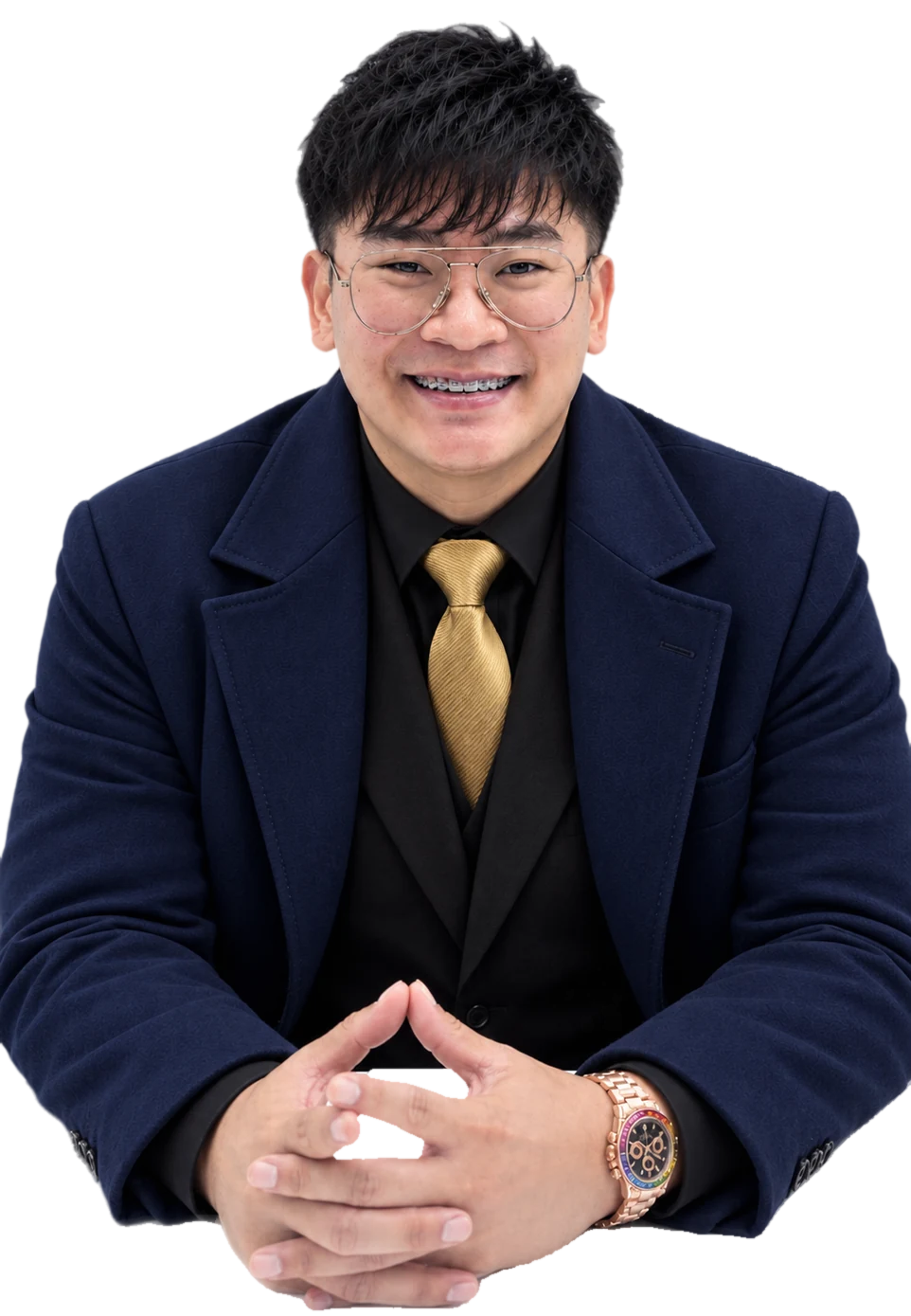 Rojie, smiling, in a navy coat with a gold tie