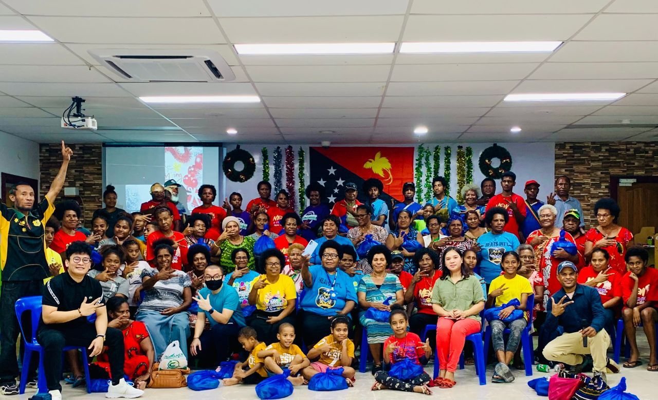 A large room of people with the flag on the wall