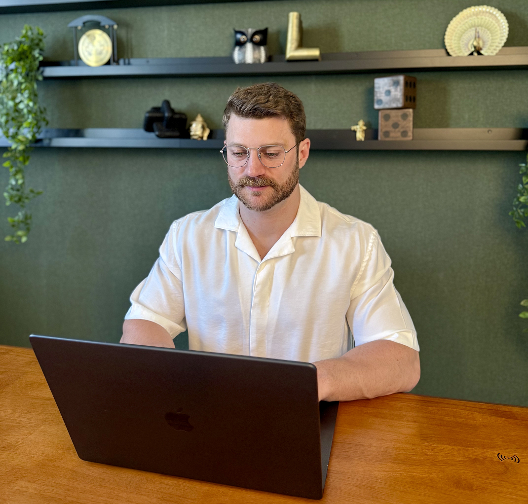 Lukas Lanx sitzt am MacBook und schreibt einen Onlinekurs als Ghostwriter