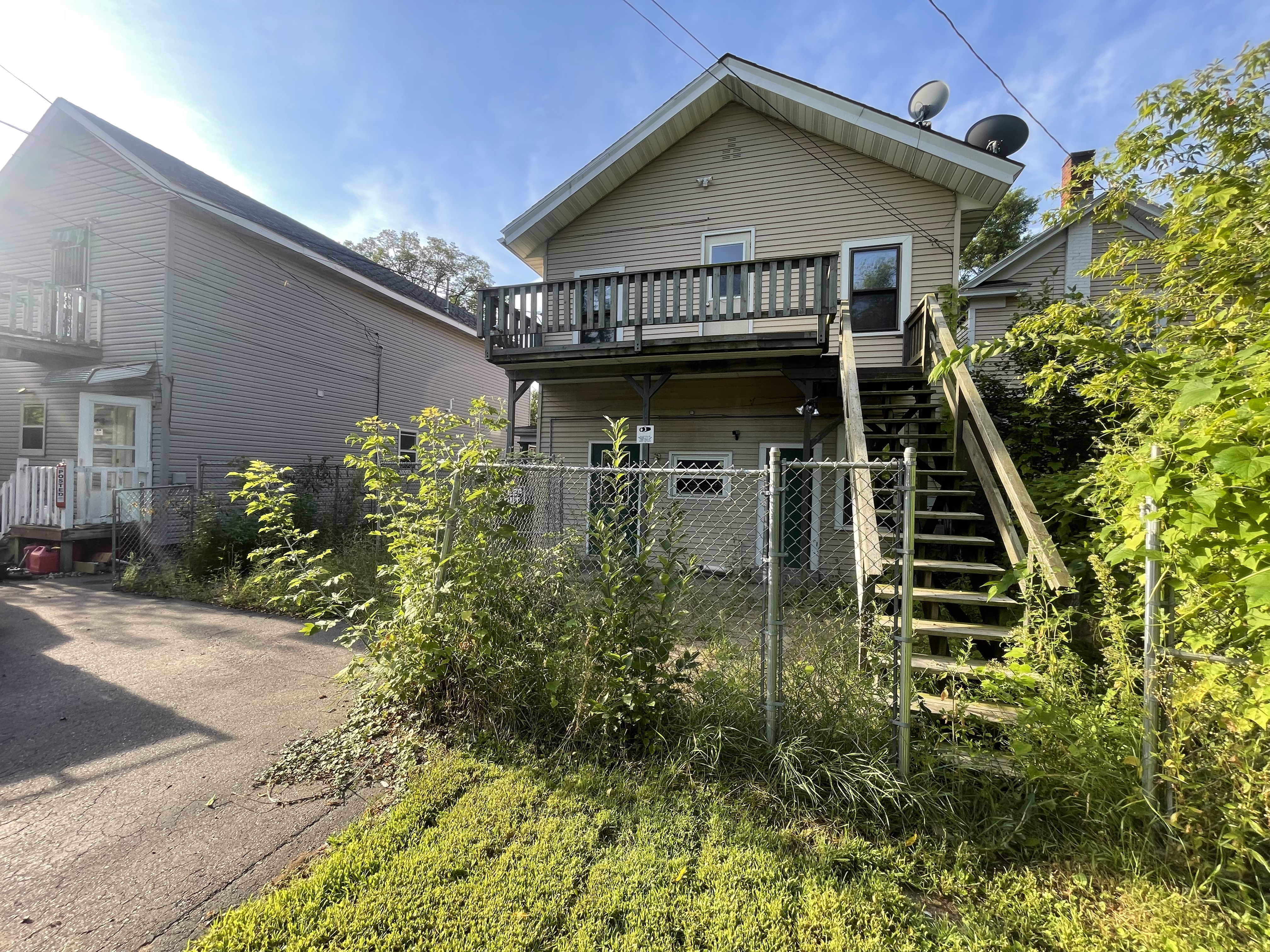 Before yard cleanup with overgrown weeds, brush, and unmaintained landscaping by Fishers Lawn Care & Snow Removal